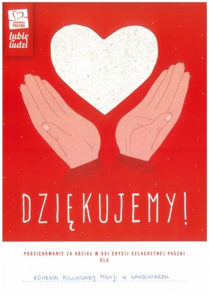 Policjanci i pracownicy cywilny przy zapakowanych prezentach zebranych w ramach akcji szlachetna paczka.